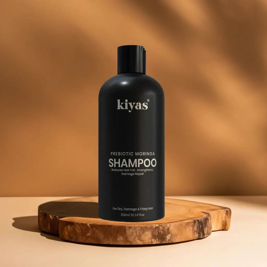 Black shampoo bottle labeled 'kiyas' on a wooden surface with a warm brown background